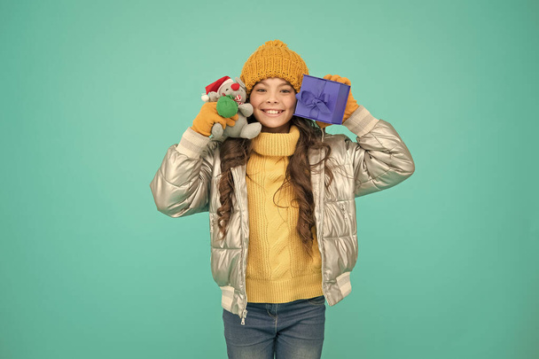 happy small girl present. shopping on xmas season. merry christmas. happy new year. Feeling grateful for good gift. fashion kid in trendy puffer jacket. warm winter clothes. online purchase bonus - Foto, afbeelding