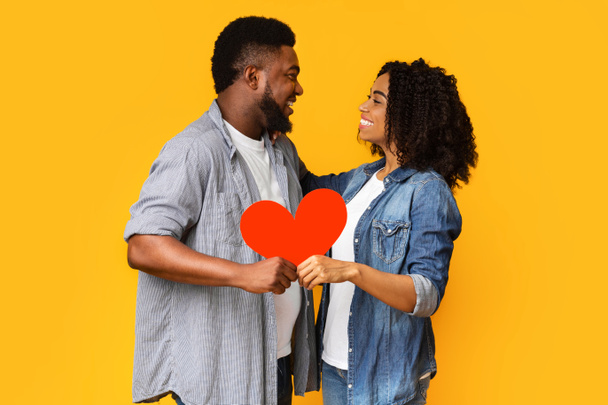 All You Need Is Love. Happy Black Couple Holding Big Red Heart - Photo, Image