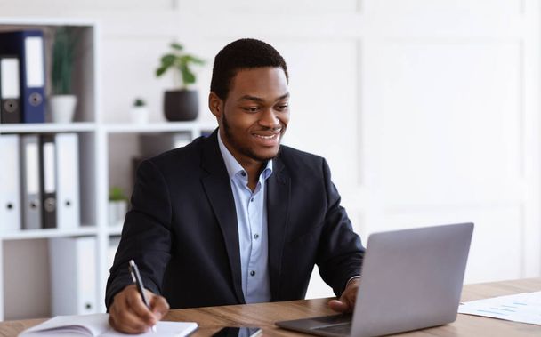 Empresário negro alegre ouvindo webinar, interior de escritório - Foto, Imagem