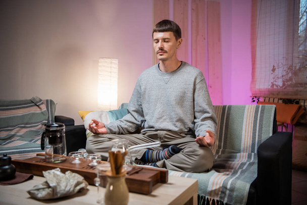 中国の伝統的なお茶を飲むマスターは、お茶が醸造されるのを待っている間、自宅で瞑想します. - 写真・画像