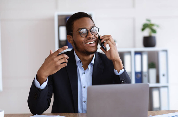 Hyvä afrikkalainen liikemies puhuu kännykkään toimistossa - Valokuva, kuva