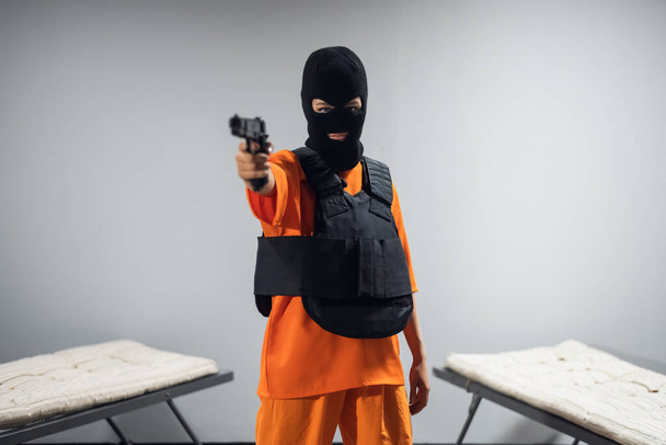 Ένα νεαρό κορίτσι παίρνει μια μάσκα, όπλα και πανοπλία και κάνει μια ένοπλη επίθεση στους δεσμοφύλακες. - Φωτογραφία, εικόνα