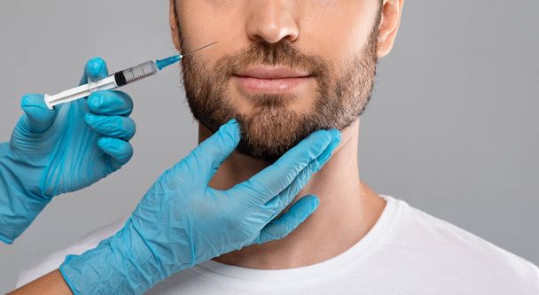 Unrecognizable bearded man getting lips filler in beauty salon, panorama - Foto, Bild
