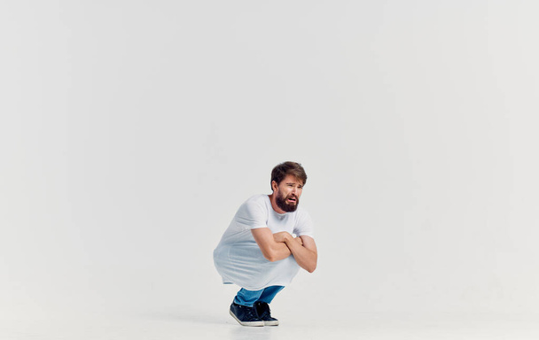 άνθρωπος σε λευκό t-shirt και τζιν συναισθήματα κίνηση στούντιο τρόπο ζωής απομονωμένη φόντο - Φωτογραφία, εικόνα