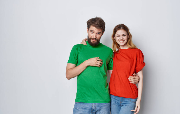 cheerful man and woman multicolored t-shirts embrace friendship emotions lifestyle - Photo, Image