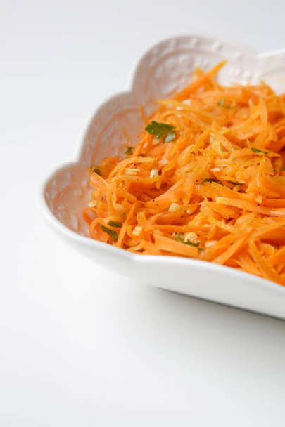 Ensalada sencilla de zanahoria en un bol, comida vegetariana fresca y saludable con perejil y aderezo de ajo - Foto, Imagen