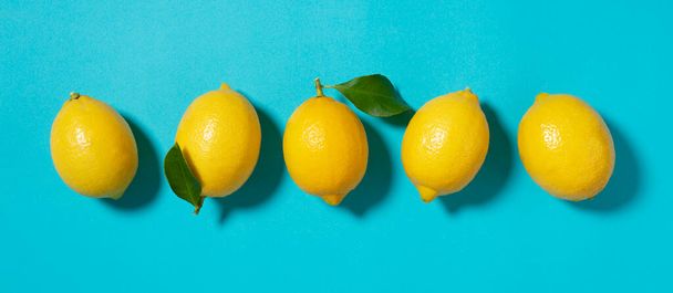 Několik citronů umístěných na modrém pozadí. Prohlíženo přímo shora - Fotografie, Obrázek