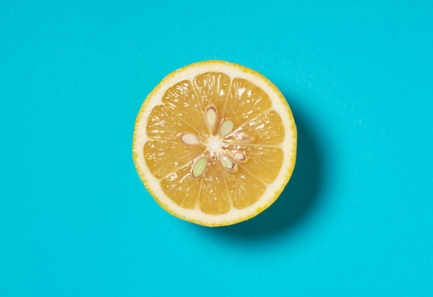 Zitronen halbiert, auf blauem Hintergrund platziert. Blick von oben - Foto, Bild