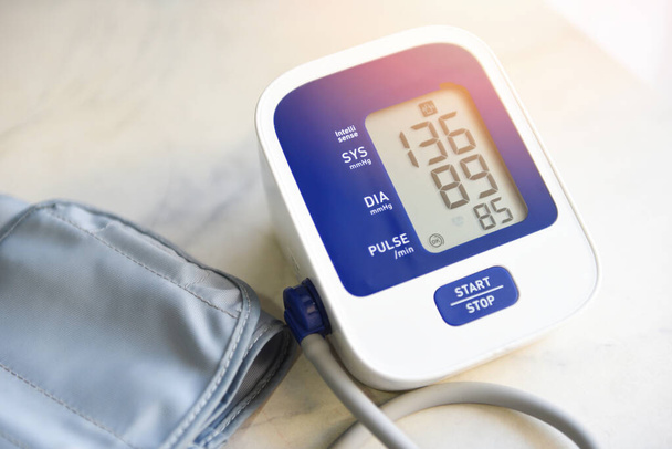 Παρακολούθηση αρτηριακής πίεσης Ψηφιακή στο τραπέζι, Ιατρικό ηλεκτρονικό τονόμετρο ελέγχου της αρτηριακής πίεσης και του καρδιακού ρυθμού Υγεία και ιατρική έννοια - Φωτογραφία, εικόνα