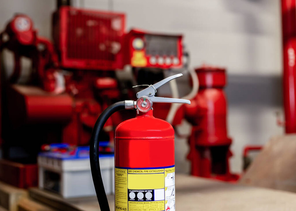 El extintor rojo está listo para su uso en caso de una emergencia de incendio en interiores. - Foto, imagen