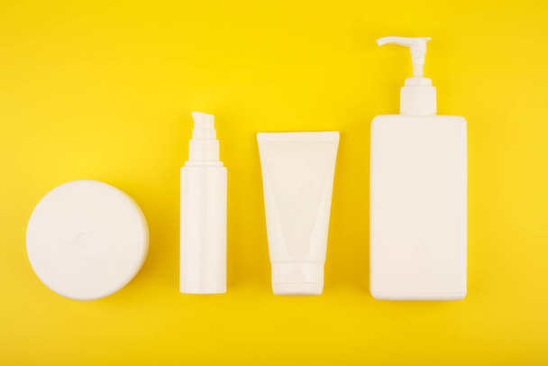 Flat lay with set of cosmetic products for skin and body care on bright yellow background - Φωτογραφία, εικόνα