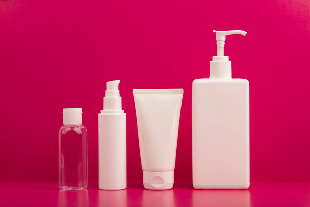 Set cosmetische producten voor huidverzorging op felroze achtergrond - Foto, afbeelding