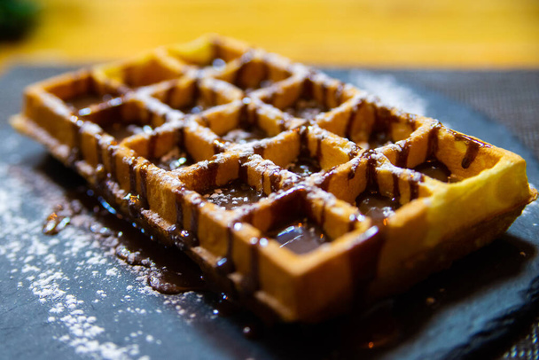Çikolata soslu ve pudra şekerli Belçika waffle 'ı.. - Fotoğraf, Görsel