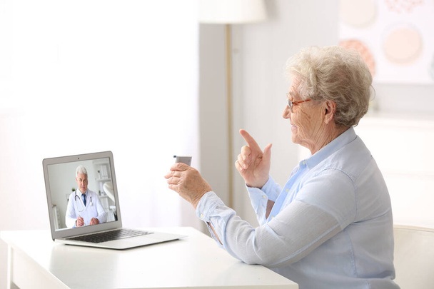 Hasta kıdemli kadın evde online danışmanlık alıyor. - Fotoğraf, Görsel