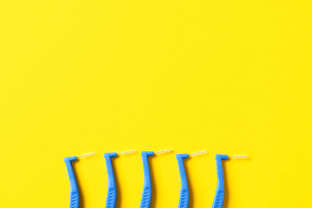 Toothbrushes for dental braces and floss on color background - 写真・画像