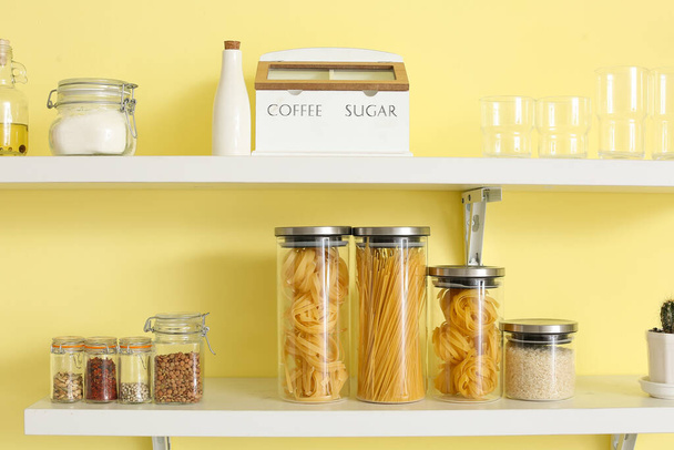Conjunto de utensílios e frascos de vidro com produtos em prateleiras de cozinha - Foto, Imagem