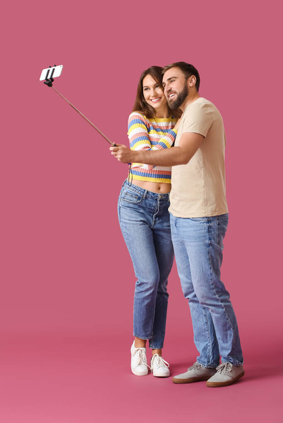 Young couple taking selfie on color background - Фото, изображение