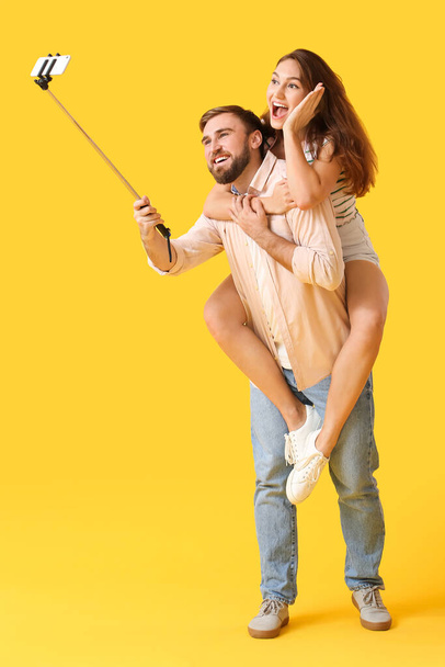 Young couple taking selfie on color background - Fotoğraf, Görsel