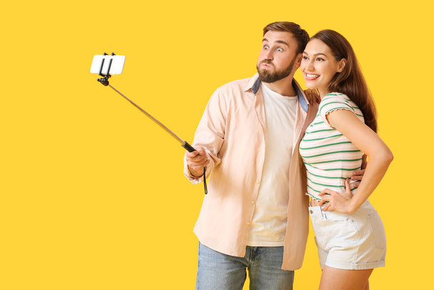 Renkli arka planda selfie çeken genç çift. - Fotoğraf, Görsel
