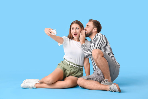 Young couple taking selfie on color background - Foto, afbeelding