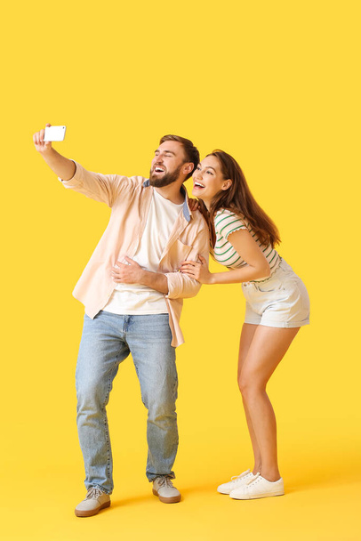 Młoda para robi selfie na tle koloru - Zdjęcie, obraz