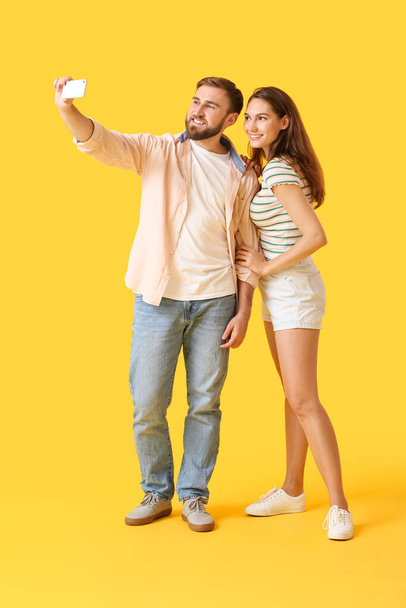 Young couple taking selfie on color background - Foto, imagen