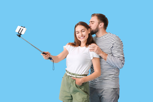 Mladý pár přičemž selfie na barevném pozadí - Fotografie, Obrázek