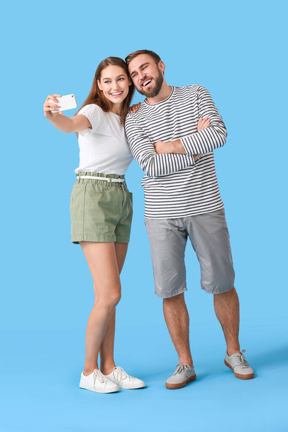 Junges Paar macht Selfie auf farbigem Hintergrund - Foto, Bild