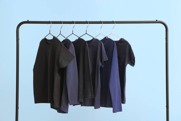 Rack with clothes on color background - Foto, imagen
