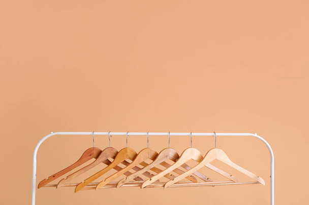 Стойка с вешалками для одежды на цветном фоне - Фото, изображение