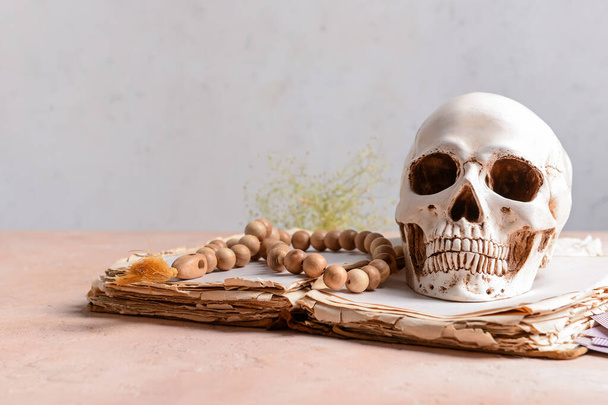 Книга орфографії, людський череп і намистини на столі
 - Фото, зображення