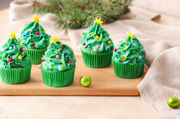 Tasty Christmas cupcakes on table - 写真・画像