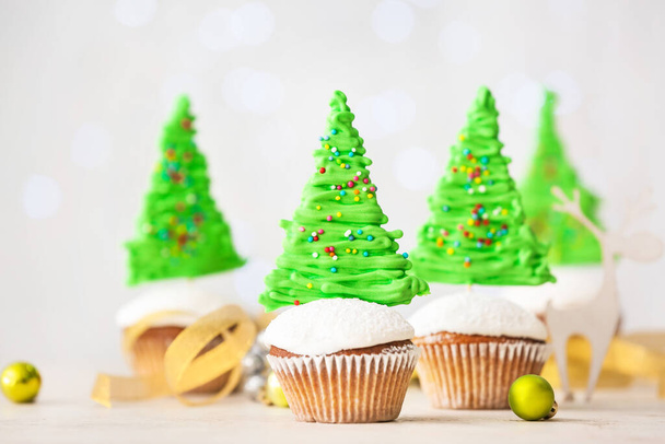 Tasty Christmas cupcakes and decor on table - Photo, Image