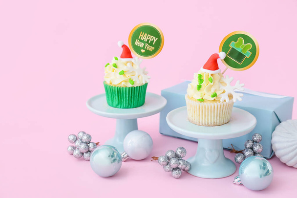 Dessert stand with tasty Christmas cupcakes on color background - Photo, Image