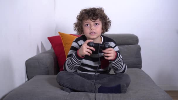 ヨーロッパ、イタリア、ミラノ- n-cov19コロナウイルス流行中のライフスタイル-子供の男の子5歳自宅でビデオゲームで遊ぶ-閉校学校 - 映像、動画