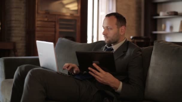 Businessman with tablet and laptop - Filmati, video