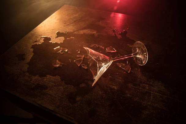 Drink, broken glass concept. Broken glasses on wooden table at dark toned background with fog. Selective focus - Φωτογραφία, εικόνα