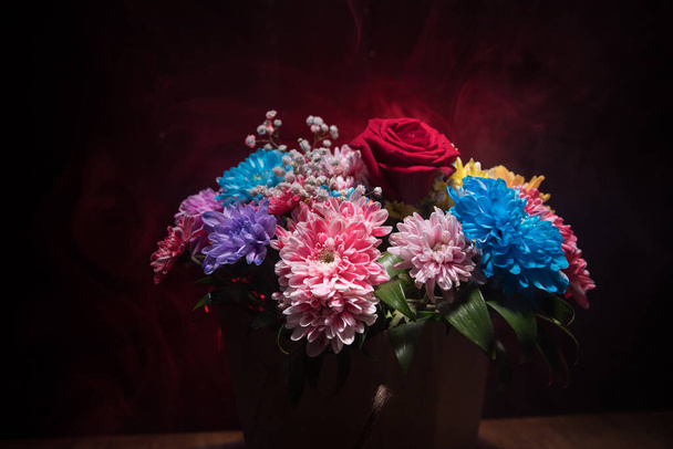 Beau et coloré bouquet de fleurs, sur fond de boulangerie sombre. Bouquet floral de différentes fleurs. Idéal pour une carte de vœux. Concentration sélective - Photo, image