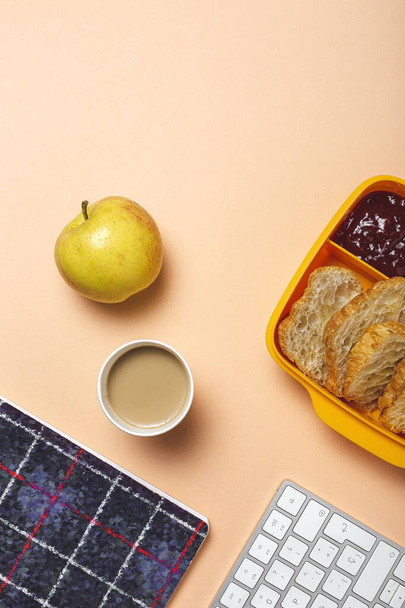 Desayuno en el lugar de trabajo casero y cruasanes con mermelada, mantequilla y café en la mesa de trabajo con teclado de computadora. entrega - Foto, imagen