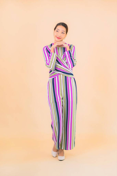 Portrét krásná mladá asijská žena úsměv relax v akci na barevném pozadí - Fotografie, Obrázek