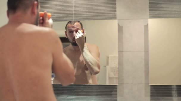 Man applying eyelid moisturizer - Πλάνα, βίντεο