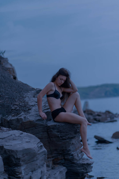 Beautiful brunette woman among the rocks. Selective focus. - Foto, Imagen