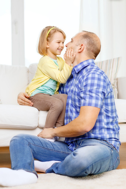 Smiling father and daughter playing at home - Фото, изображение