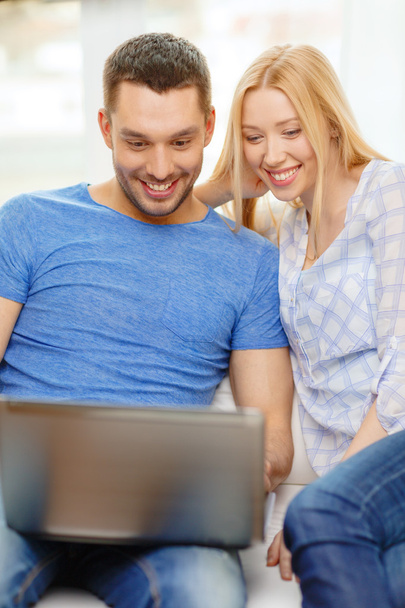 Smiling happy couple with laptop at home - Fotografie, Obrázek