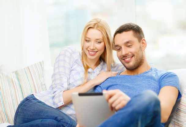 Smiling happy couple with tablet pc at home - Foto, afbeelding
