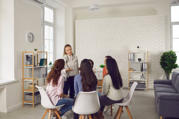 Group of women sitting in circle and listening to professional business or life coach - Foto, immagini
