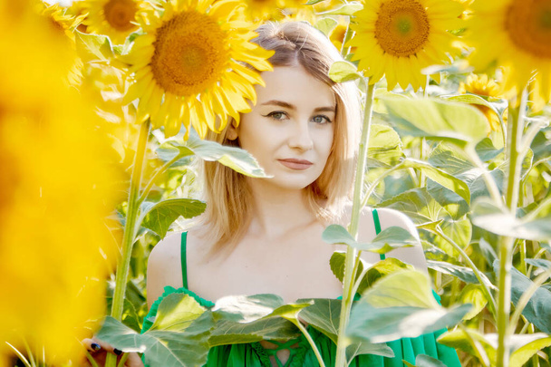 beautiful young girl in sunflowers happy smiling - Foto, afbeelding