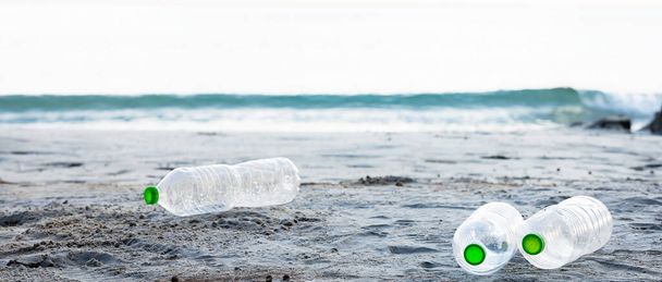 Trois bouteilles en plastique vert clair sur la plage de sable fin. Poubelles et nature. - Photo, image