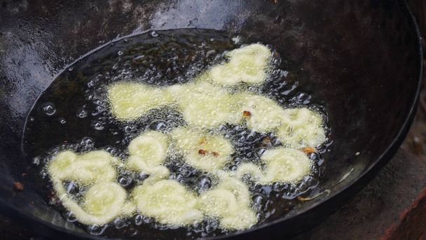 Fabricación de comida callejera india jilebi, freír profunda de maida o masa de harina simple antes de empapar en jarabe azucarado - Foto, Imagen