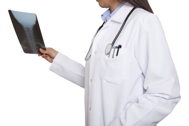 Женщина-врач изучает рентгеновский снимок. В смотровой в больнице. Медицина и здравоохранение. - Фото, изображение